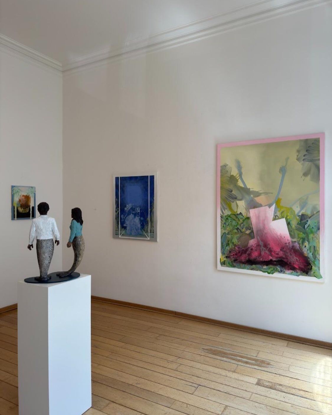 Exhibition room at Galerie Löhrl with paintings by Steffen Meister on white walls and a sculpture in the foreground.